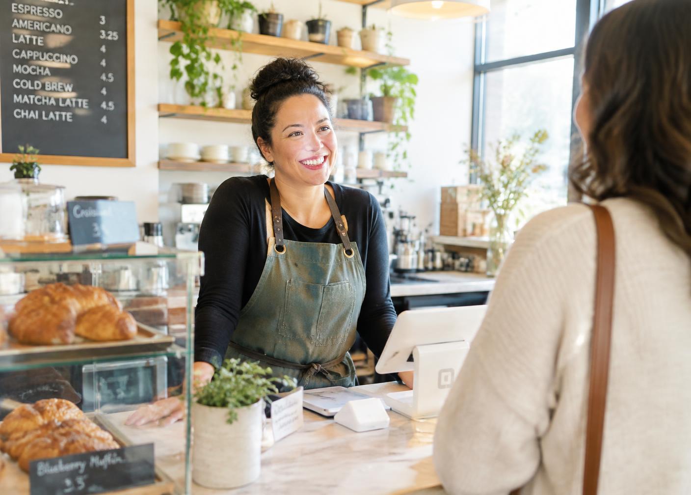 Local business owner greeting a customer at the counter